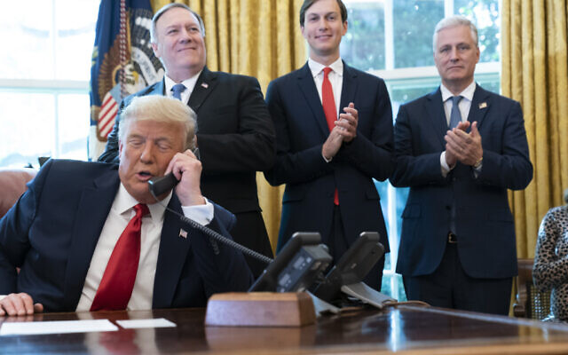 President Donald Trump talks on a phone call with the leaders of Sudan and Israel, as Secretary of State Mike Pompeo, left, White House senior adviser Jared Kushner, and National Security Adviser Robert O'Brien, applaud in the Oval Office of the White House, Friday, Oct. 23, 2020, in Washington. (AP Photo/Alex Brandon)