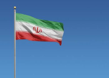 Flag of Iran in front of a clear blue sky