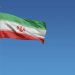 Flag of Iran in front of a clear blue sky