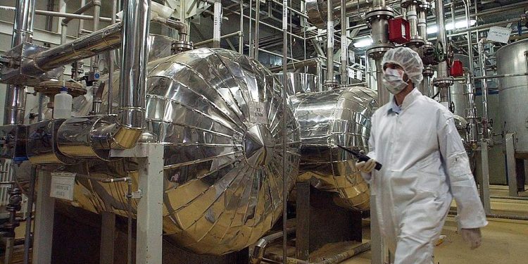 Wearing protective clothes, an Iranian security person walks at a part of the Uranium Conversion Facility, prior to the arrival of Iranian President Mohammad Khatami, just outside the city of Isfahan, 410 kilometers, south of the capital Tehran, Iran, Wednesday, March 30, 2005. The conversion facility in Isfahan reprocesses uranium ore concentrate, known as yellowcake, into uranium hexaflouride gas. The gas is then taken to Natanz and fed into the centrifuges for enrichment. (AP Photo/Vahid Salemi)