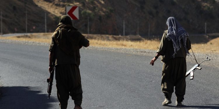 A member of the Kurdistan Workers' Party (PKK) carries an automatic rifle on a road in the Qandil Mountains, the PKK headquarters in northern Iraq, on June 22, 2018. - Hundreds of Iraqi Kurds marched Friday to protest Turkish strikes against the Kurdistan Workers' Party (PKK) after Turkey's President Recep Tayyip Erdogan said Ankara would press an operation against its bases. (Photo by SAFIN HAMED / AFP)        (Photo credit should read SAFIN HAMED/AFP via Getty Images)