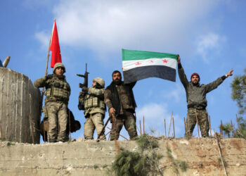 Turkish forces and Free Syrian Army members hold flags on Mount Barsaya, northeast of Afrin, Syria January 28, 2018. REUTERS/ Khalil Ashawi - RC1CD80C4D00