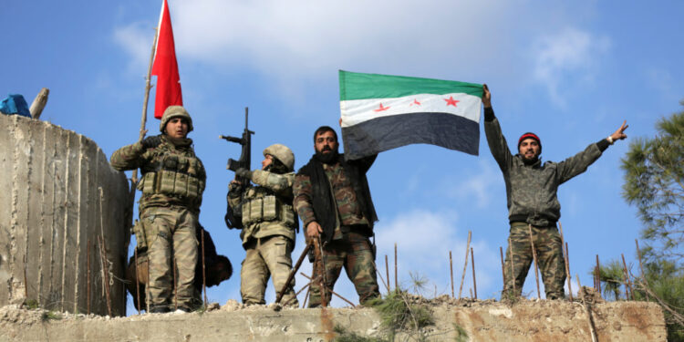 Turkish forces and Free Syrian Army members hold flags on Mount Barsaya, northeast of Afrin, Syria January 28, 2018. REUTERS/ Khalil Ashawi - RC1CD80C4D00