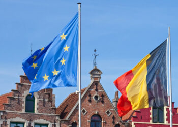 BRUGES, BELGIUM – APRIL 16, 2014: Four flags Blowing in the wind, background historic houses at the Markt in Bruges