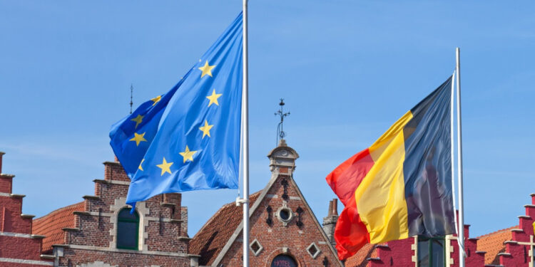 BRUGES, BELGIUM – APRIL 16, 2014: Four flags Blowing in the wind, background historic houses at the Markt in Bruges