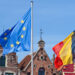 BRUGES, BELGIUM – APRIL 16, 2014: Four flags Blowing in the wind, background historic houses at the Markt in Bruges