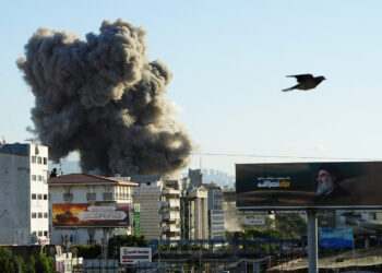 A billboard depicting late Hezbollah leader Sayyed Hassan Nasrallah is pictured as smoke billows after an Israeli strike, amid the ongoing hostilities between Hezbollah and Israeli forces, in Beirut's southern suburbs, Lebanon, November 16, 2024. REUTERS/Mohammed Yassin     TPX IMAGES OF THE DAY
