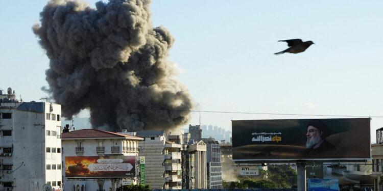A billboard depicting late Hezbollah leader Sayyed Hassan Nasrallah is pictured as smoke billows after an Israeli strike, amid the ongoing hostilities between Hezbollah and Israeli forces, in Beirut's southern suburbs, Lebanon, November 16, 2024. REUTERS/Mohammed Yassin     TPX IMAGES OF THE DAY