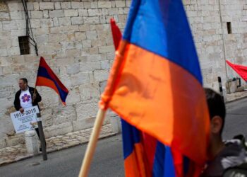 FILE - Armenians hold their national flag during a ceremony to commemorate the mass killings of Armenians by the Ottoman Empire, in Jerusalem, Israel, Friday, April 24, 2015. (AP Photo/Oded Balilty, File)