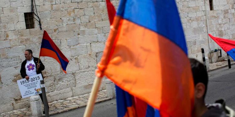 FILE - Armenians hold their national flag during a ceremony to commemorate the mass killings of Armenians by the Ottoman Empire, in Jerusalem, Israel, Friday, April 24, 2015. (AP Photo/Oded Balilty, File)