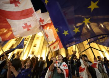 Protesters wave Georgian national and European flags during a demonstration outside the parliament building as they protest against a draft bill on "foreign influence" in Tbilisi on April 17, 2024. Thousands rallied in Georgia on April 17, 2024 after lawmakers advanced a controversial "foreign influence" law that opponents say will undermine Tbilisi's longstanding European aspirations. (Photo by Giorgi ARJEVANIDZE / AFP)